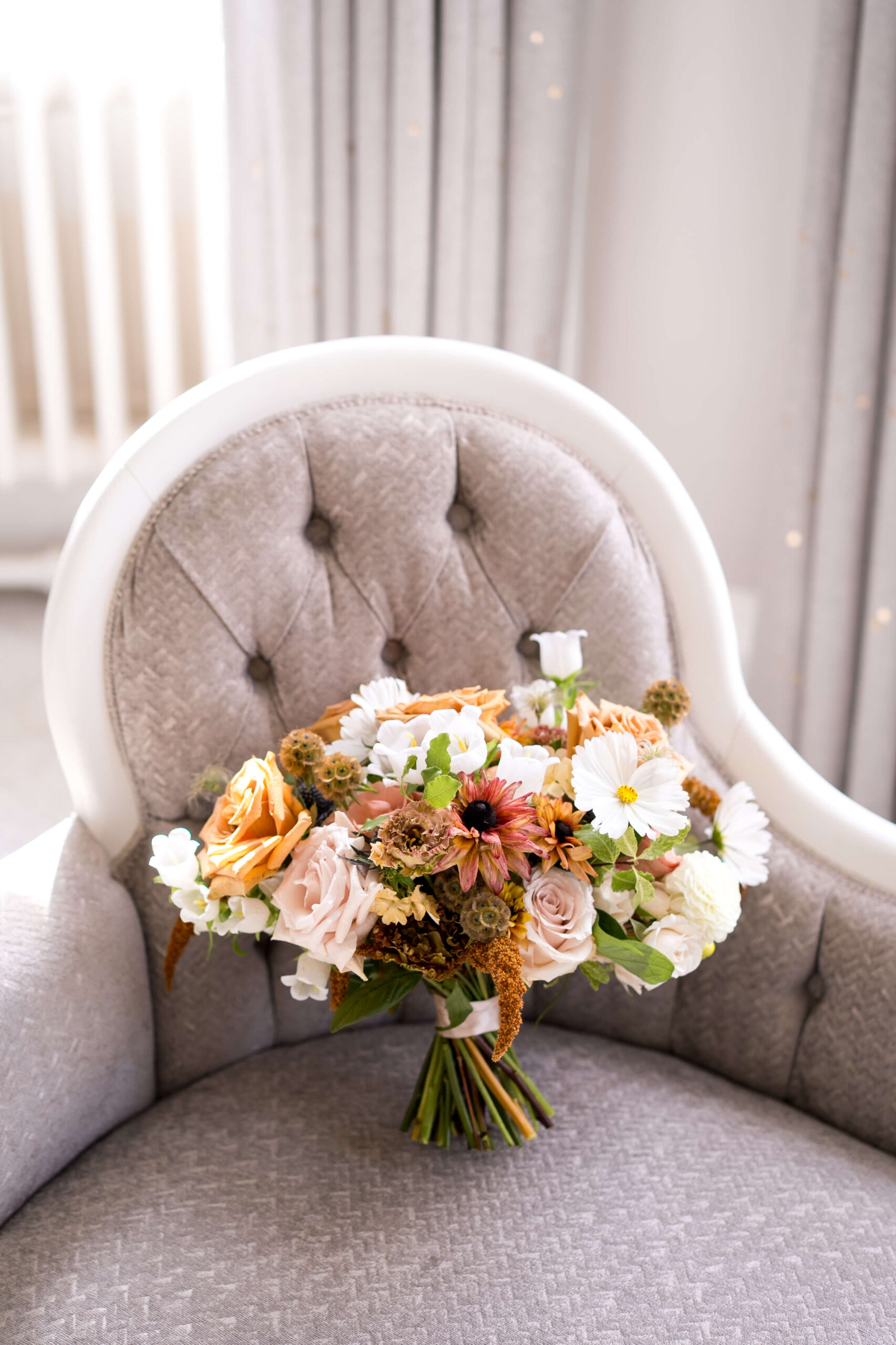 A bridal bouquet of toffee roses, white cosmos, campanula, hot biscuit, phlox for this early autumn wedding at Eastington Park
